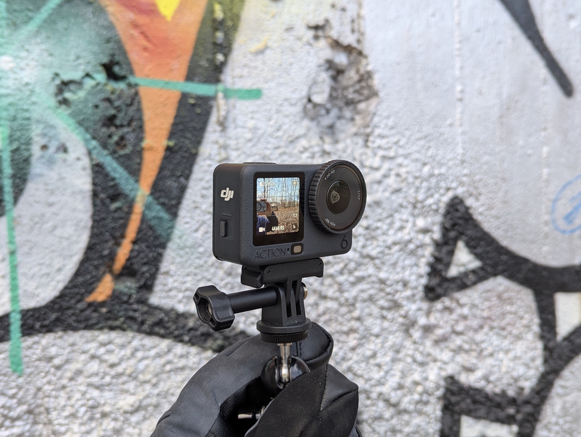 DJI Osmo Action 6 davanti a un muro di graffiti