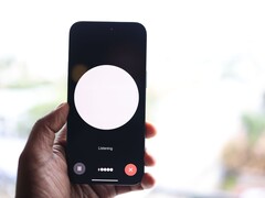 Una mano che regge uno smartphone con l’interfaccia di un assistente vocale sullo schermo