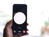 Una mano che regge uno smartphone con l’interfaccia di un assistente vocale sullo schermo