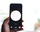 Una mano che regge uno smartphone con l’interfaccia di un assistente vocale sullo schermo