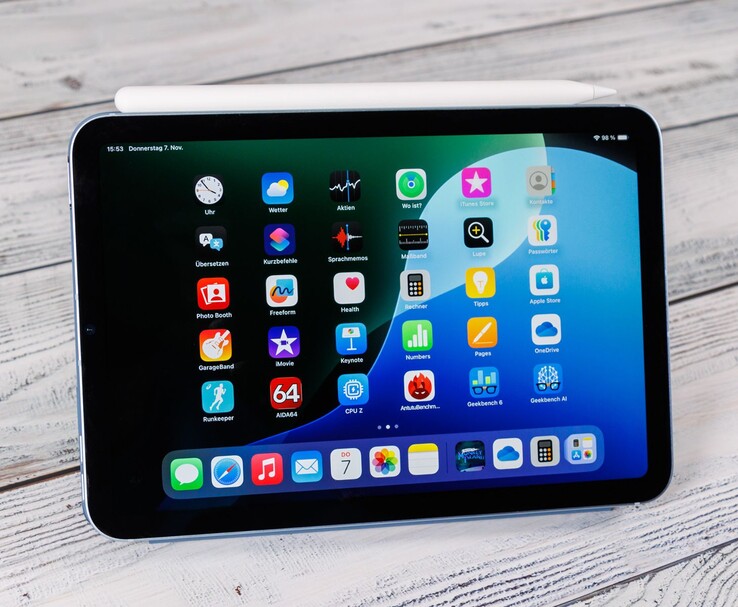 Vista frontale di un iPad mini con la Pencil Apple appoggiata sopra, che mostra la schermata iniziale mentre è appoggiato su una superficie di legno. (Fonte: Notebookcheck)