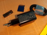Il caricabatterie e il cavo, una scheda SD e una pen drive USB per la scala (Fonte immagine: Sergey Tarasov - Notebookcheck)