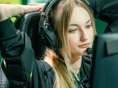 Uno streamer che indossa cuffie da gioco dotate di microfono a braccio davanti a uno schermo durante una trasmissione in diretta