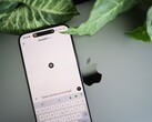 Smartphone con l’app ChatGPT aperta, appoggiato su un laptop accanto alle foglie di una pianta