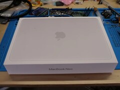 La scatola di MacBook Neo è stata posizionata su un banco di lavoro prima dello smontaggio per l'aggiornamento dell'SSD