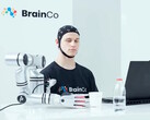 Un utente della tecnologia di controllo mentale di BrainCo che afferra meccanicamente una mela con il solo potere del pensiero.