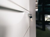 Una chiave inserita nella serratura di un cassetto di legno chiuso