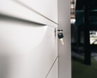 Una chiave inserita nella serratura di un cassetto di legno chiuso