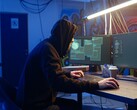 Un hacker generico su una postazione di lavoro a doppio monitor che esegue un attacco alla catena di approvvigionamento.
