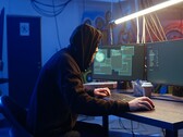 Un hacker generico su una postazione di lavoro a doppio monitor che esegue un attacco alla catena di approvvigionamento.