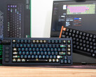 Tastiere Lemokey L1 HE Keychron K4 HE ad effetto Hall su una scrivania davanti a una scatola e a un computer portatile