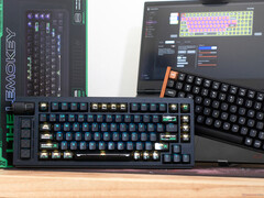 Tastiere Lemokey L1 HE Keychron K4 HE ad effetto Hall su una scrivania davanti a una scatola e a un computer portatile