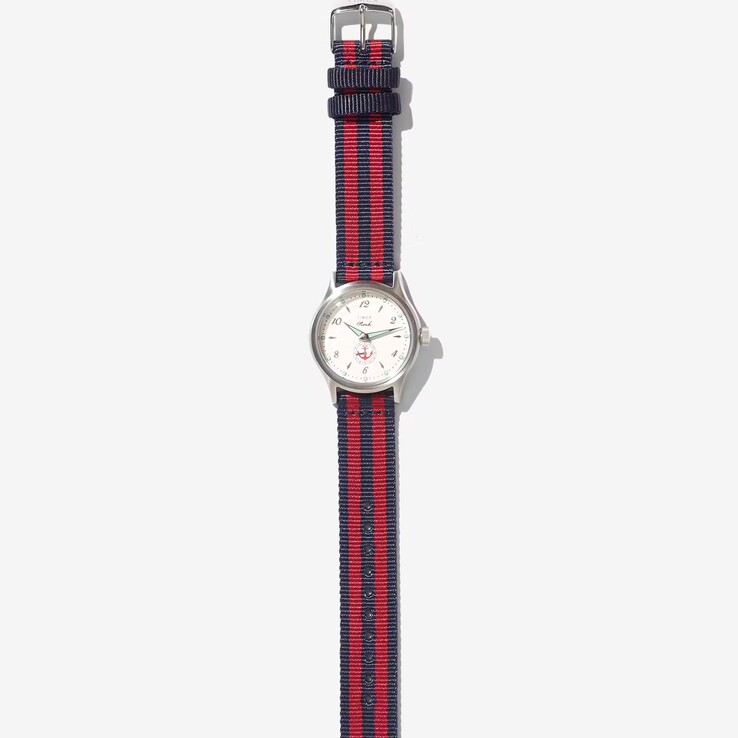 Orologio Noah x Timex MK1 Anchor con cassa color argento da 36 mm, quadrante color crema, motivo a forma di ancora e cinturino in tessuto a righe blu navy e rosse.