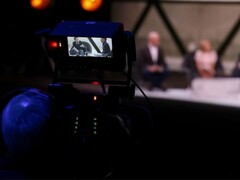 Una fotografia di una telecamera che riprende un'intervista