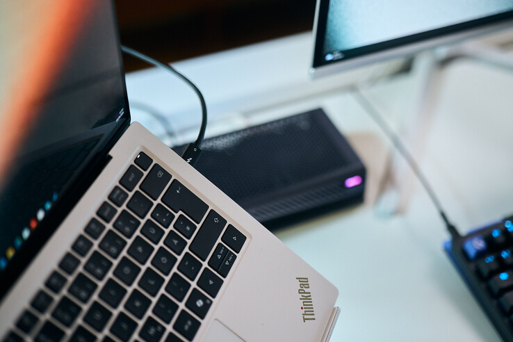 Inquadratura ravvicinata di un cavo Thunderbolt 5 collegato alla porta laterale di un laptop Lenovo ThinkPad X9, con l’eGPU Aorus sullo sfondo.