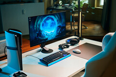 Una configurazione da gaming essenziale in studio, caratterizzata dal monitor Sony Inzone M10S II posizionato su una scrivania bianca, affiancato da una console PlayStation 5 Pro in posizione verticale, una tastiera meccanica, un mouse wireless e cuffie con una delicata illuminazione blu.