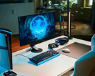 Una configurazione da gaming essenziale in studio, caratterizzata dal monitor Sony Inzone M10S II posizionato su una scrivania bianca, affiancato da una console PlayStation 5 Pro in posizione verticale, una tastiera meccanica, un mouse wireless e cuffie con una delicata illuminazione blu.