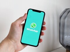 Mano che tiene uno smartphone con l'app WhatsApp aperta
