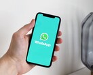 Mano che tiene uno smartphone con l'app WhatsApp aperta