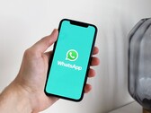 Mano che tiene uno smartphone con l'app WhatsApp aperta