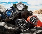 Quattro orologi subacquei Citizen Promaster Marine nei colori bianco, nero, blu e arancione, esposti su alcune rocce in riva al mare.