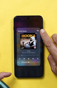 Uno smartphone OnePlus su cui è visualizzato il widget del lettore multimediale; un utente sta toccando l'icona dell'uscita audio per accedere ai comandi di condivisione audio tramite Bluetooth.
