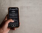 Mano che tiene uno smartphone con l'interfaccia di ChatGPT visualizzata sullo schermo sopra una superficie in pietra grigia