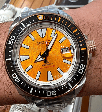 Primo piano dell’orologio Seiko Prospex HBB005K1 che mostra il quadrante color ambra con finitura testurizzata, gli indici luminescenti sovradimensionati, le lancette larghe, il datario e la lunetta subacquea nera con indicatori arancioni.