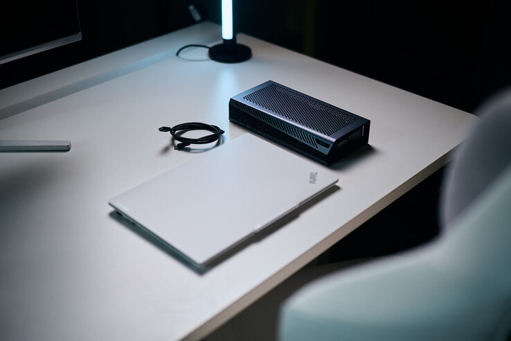 Un portatile ThinkPad bianco chiuso, posizionato accanto alla compatta eGPU Aorus RTX 5060 Ti AI Box e a un cavo Thunderbolt a spirale su una scrivania.