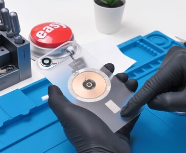 Vetro posteriore trasparente dell'iPhone Air con bobina di ricarica wireless in rame visibile e modulo fotocamera durante il processo di modding. (Fonte: Phone Repair Guru via YouTube)
