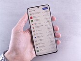 Una mano regge uno smartphone sul cui schermo è visualizzato un elenco di aggiornamenti.
