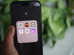 Mano che tiene uno smartphone con una cartella piena di app di IA sullo schermo