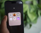 Mano che tiene uno smartphone con una cartella piena di app di IA sullo schermo