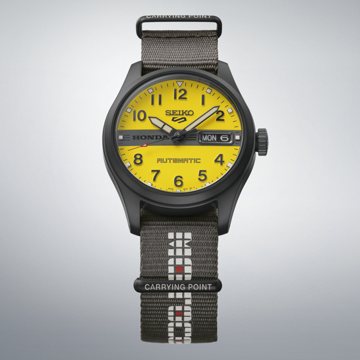 Vista frontale del Seiko 5 Sports Field x Honda Motocompo Limited Edition con quadrante giallo, logo Honda nero al centro e cinturino in nylon grigio.