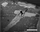 Un'immagine al microscopio elettronico a scansione di un cratere da impatto di un micrometeorite in una particella di materiale dell'asteroide Bennu (Fonte immagine: NASA, e Zia Rahman)