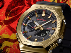 Il Casio G-Shock GBM-2100CX-9AJR con lunetta in oro incisa, raffigurato su uno sfondo rosso stilizzato. (Fonte: Casio Japan)