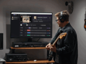 Un chitarrista suona davanti a un monitor che mostra l'app StemKit