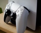 Un'immagine di un controller DualSense per PlayStation 5 appoggiato a una console PS5