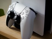 Un'immagine di un controller DualSense per PlayStation 5 appoggiato a una console PS5