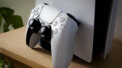 Un'immagine di un controller DualSense per PlayStation 5 appoggiato a una console PS5