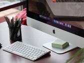 Un iMac su una scrivania con il dock di macOS visibile sullo schermo e una tastiera Apple davanti