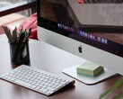 Un iMac su una scrivania con il dock di macOS visibile sullo schermo e una tastiera Apple davanti
