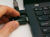 Una persona inserisce una chiavetta USB di sicurezza in un computer portatile