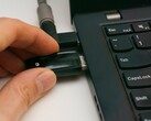 Una persona inserisce una chiavetta USB di sicurezza in un computer portatile