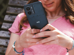 Un&#039;immagine promozionale dello smartphone Fusion di HMD che mostra il telefono nelle mani di una donna con un primo piano del logo HMD sul retro. (Fonte immagine: HMD)