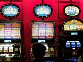 Slot machine all'interno di un casinò con display luminosi e persone che giocano davanti (Fonte immagine: djedj via Pixabay)