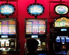 Slot machine all'interno di un casinò con display luminosi e persone che giocano davanti (Fonte immagine: djedj via Pixabay)