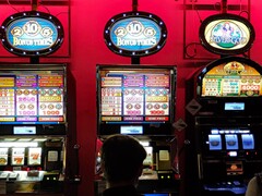 Slot machine all&#039;interno di un casinò con display luminosi e persone che giocano davanti (Fonte immagine: djedj via Pixabay)