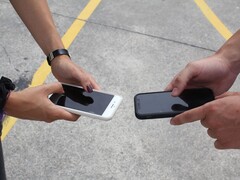 Due persone che tengono due smartphone uno accanto all'altro durante una consegna