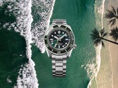 Orologio subacqueo Seiko Prospex HBC001 con quadrante e lunetta verdi visualizzati su uno sfondo aereo di spiaggia e oceano.